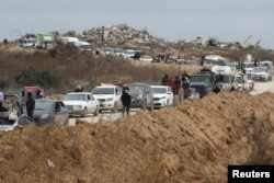 Palestinians wait to cross through a checkpoint run by U.S. and Egyptian security contractors after Israeli forces withdrew from the Netzarim Corridor, near Gaza City, Feb. 9, 2025.