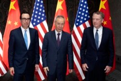 FILE - Chinese Vice Premier Liu He, center, poses with U.S. Trade Representative Robert Lighthizer, right, and Treasury Secretary Steven Mnuchin, for photos before holding talks at the Xijiao Conference Center in Shanghai, July 31, 2019.