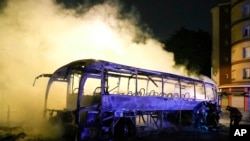 Bomberos usan manguera de agua en un autobús incendiado en Nanterre, en las afueras de París, Francia, el 1 de julio de 2023. El presidente francés, Emmanuel Macron propuso restricciones en las redes sociales para sofocar los disturbios que se extienden por Francia.