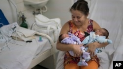 Severina Raimunda porte dans ses bars sa petite-fille Melisa Vitoria, à gauche, qui est né avec une microcéphalie et son frère jumeau Edison junior à l'hôpital de IMIP à Recife, dans l'Etat de Pernambuco, au Brésil, 3 février 2016. 