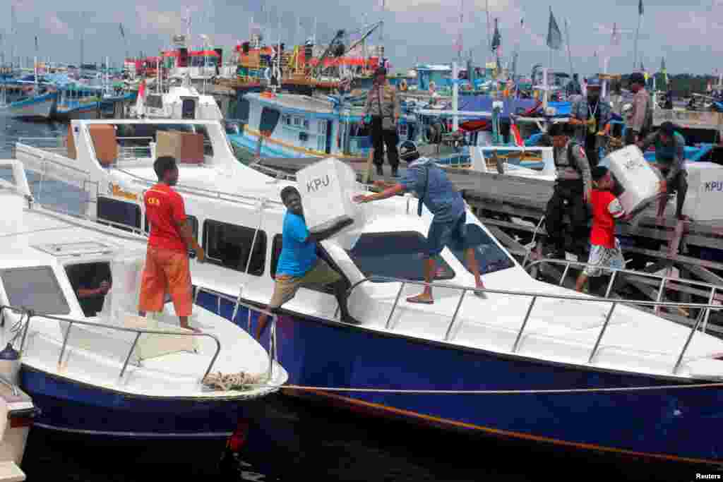 Para pekerja memuat barang-barang keperluan pemilu ke dalam sebuah kapal untuk didistribusikan ke Sorong, Papua Barat, 16 April 2019. (Foto: Antara Foto/Olha Mulalinda/ via REUTERS)