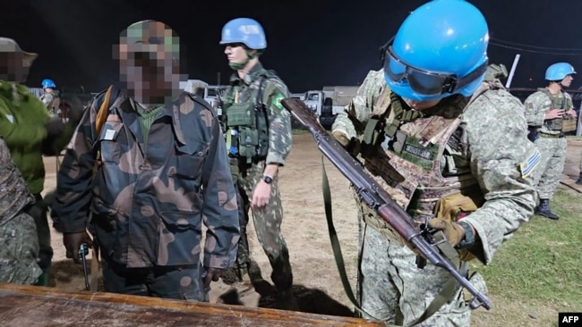 This handout picture released on Jan. 26, 2025, by the Uruguayan Army shows soldiers of the Armed Forces of the Democratic Republic of the Congo reportedly handing over their weapons to Uruguayan soldiers of the United Nations Organization Stabilization Mission in Goma.