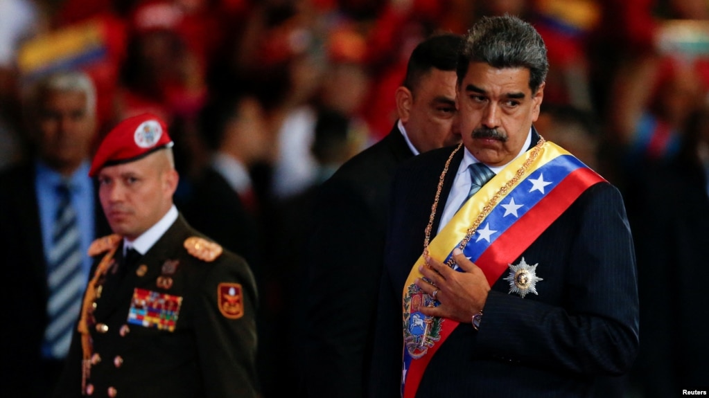 El gobernante venezolano Nicolás Maduro gesticula durante su mensaje anual en un teatro de Caracas, junto a un oficial militar, el 16 de enero de 2025.