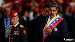 El gobernante venezolano Nicolás Maduro gesticula durante su mensaje anual en un teatro de Caracas, junto a un oficial militar, el 16 de enero de 2025.