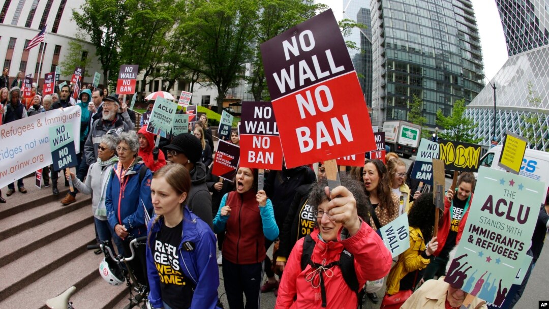 FILE - Protesters wave signs and chant during a demonstration against President Donald Trump's travel ban, outside a federal courthouse in Seattle, Washington, May 15, 2017. 