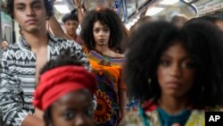 FILE - Models wear outfits designed by students from Afro-Brazilian communities at a subway station as part of Black Consciousness Awareness Month, in Sao Paulo, Brazil, November 19, 2021.