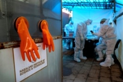 Protective gloves hang by a testing booth as health workers prepare for the day at a COVID-19 testing center in Kohima, capital of the northeastern Indian state of Nagaland, Oct. 10, 2020.
