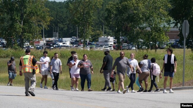 Personas caminan segpun las indicaciones de un agente cerca de la escuela secundaria Apalachee en Winder, Georgia, EEUU, el 4 de septiembre de 2024