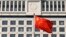 Chinese flag billows outside Shandong Province Supreme People's Court in Jinan, Oct. 24, 2013.