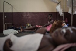 FILE - A mother watches her HIV-positive child in the intensive care unit of the Bangui pediatric complex, while in the foreground, an HIV-positive child sleeps, in Central African Republic, Dec. 4, 2018.