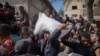 FILE - Palestinians gather to receive bags of flour distributed by UNRWA, the U.N. agency helping Palestinian refugees, in Deir al-Balah, central Gaza Strip, Nov. 2, 2024.