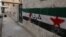 A wall with the Syrian revolutionary flag and Arabic writing which reads "freedom," northern Syria, June 3, 2012.