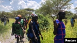 Sud-soudanaises marchant sur le site d'une décharge aérienne d'aide alimentaire du PAM près de Katdalok, dans l'État de Jonglei au Soudan du Sud, le 30 juillet 2018.