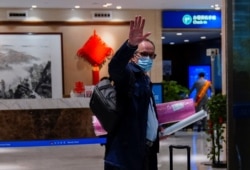 FILE - Peter Ben Embarek, a member of the World Health Organization team tasked with investigating the origins of COVID-19, waves as he arrives at the airport to leave Wuhan, Hubei province, China, Feb. 10, 2021.