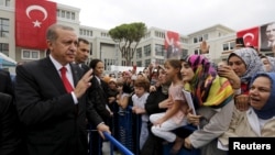 FILE - Turkey's President Tayyip Erdogan (L) greets students and parents during a ceremony to mark the start of the new school year at Ahmet Sani Gezici Girls' Imam Hatip School in Istanbul, Turkey.