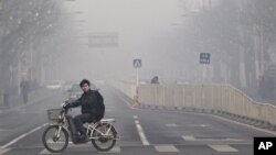 Seorang warga melintasi jalanan Beijing yang penuh asap polusi (foto: dok). Pemerintah China menerapkan target ambisius untuk menciptakan udara bersih di wilayah perkotaan. 