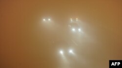 Picture taken on January 14, 2013 shows vehicles running slowly in heavy fog in Hefei, central China's Anhui province. 