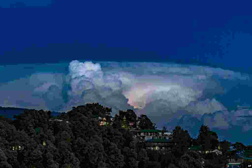 A flash of lightning lights up a raincloud hovering over a township in Dharmsala, India.