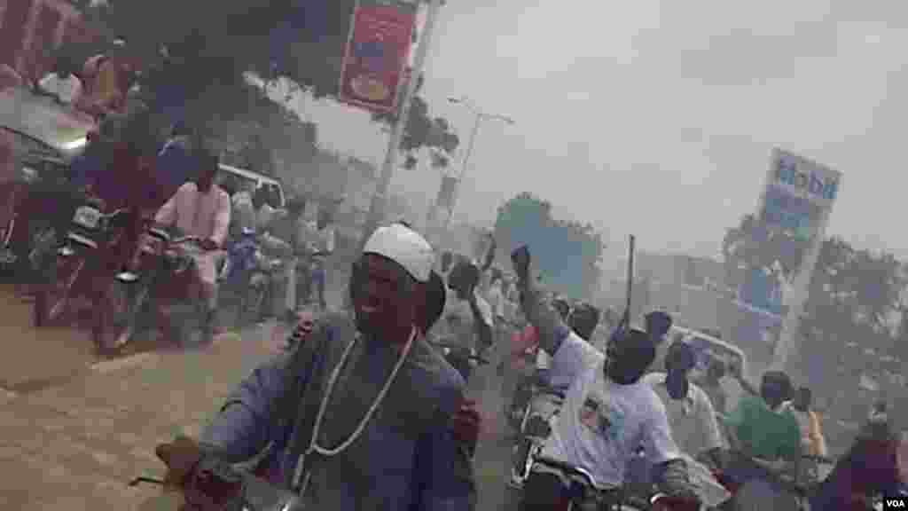 People on motorbikes follow Al-Mustapha as he arrives in Kano.