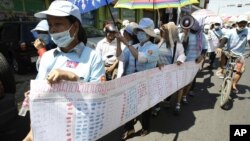 Cambodian protesters from Boueng Kak lake march with a banner displaying the thumb prints of fellow land owners who have been evicted from their homes, as they demand compensation, in Phnom Penh, Cambodia. 