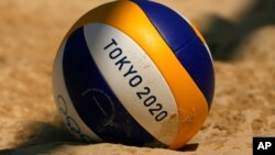 Un balón descansa en la arena durante la práctica de voleibol playa femenino, el 19 de julio de 2021, en Tokio.