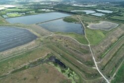 FILE - A reservoir of an old phosphate plant, the site of a breach which is leaking polluted water into the surrounding area, prompting an evacuation order in Manatee County, is seen in an aerial photo taken in Piney Point, Florida, April 3, 2021.