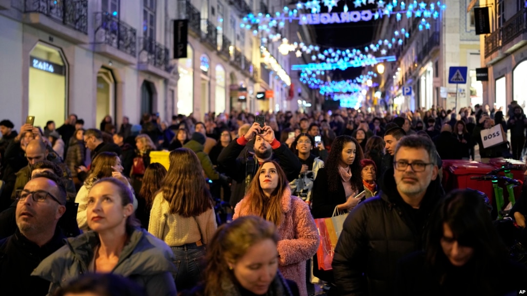 Varias personas contemplan las luces de Navidad en el barrio de Chiado, en el centro de Lisboa, Portugal, el sábado 23 de diciembre de 2023.