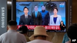 A TV shows a file image of North Korean leader Kim Jong Un, third from left, and South Korean President Moon Jae-in, second from left, during a news program at the Seoul Railway Station in Seoul, South Korea, Tuesday, July 27, 2021. North and South…