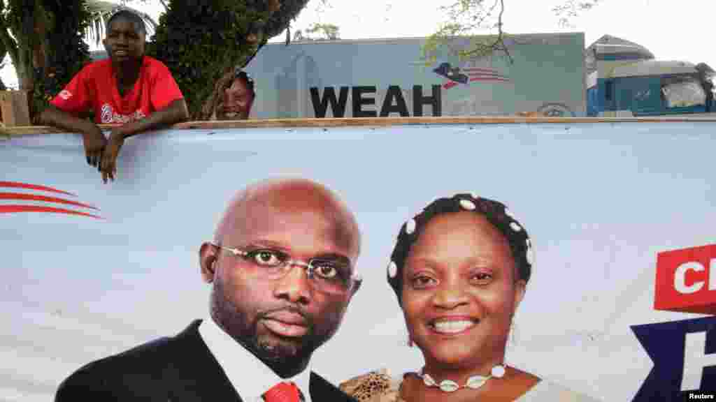 Un partisan de l'ancien footballeur et candidat à la présidence du Congrès pour le changement démocratique (CDC) George Weah se tient derrière une bannière de la campagne présidentielle à Monrovia, Libéria, le 6 octobre 2017.