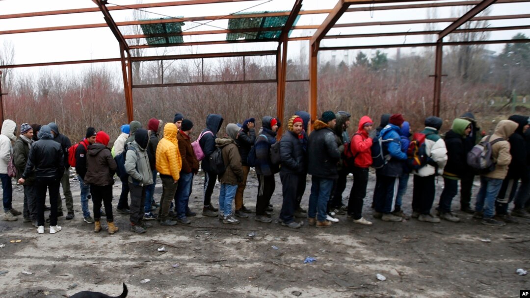 Migran mengantri makanan di sebuah pabrik yang ditinggalkan di kota Sid, Serbia barat, dekat perbatasan Serbia dengan anggota Uni Eropa, Kroasia, Senin, 18 Desember 2017.