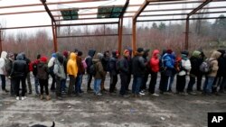 Migran mengantri makanan di sebuah pabrik yang ditinggalkan di kota Sid, Serbia barat, dekat perbatasan Serbia dengan anggota Uni Eropa, Kroasia, Senin, 18 Desember 2017.