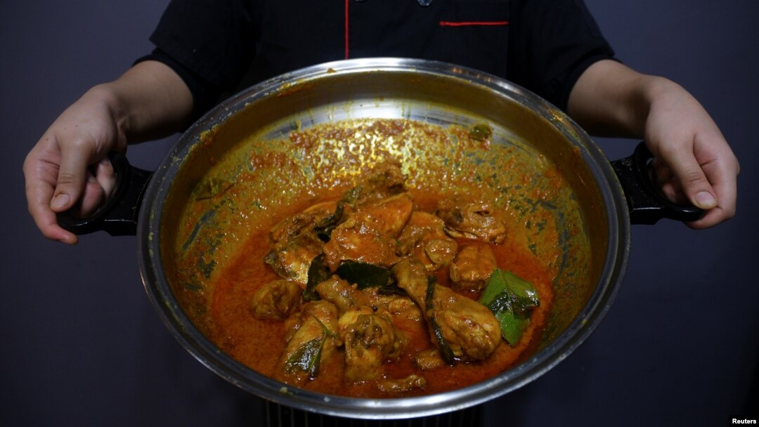 Seorang chef menunjukkan sepanci rendang ayam di sebuah restoran di Cyberjaya, Selangor, Malaysia, 4 April 2018.