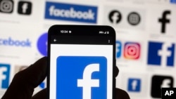 FILE -The Facebook logo is seen on a cell phone on Oct. 14, 2022, in Boston. 184 former Facebook content moderators based in Kenya have sued the site's parent company, Meta, over working conditions and pay.