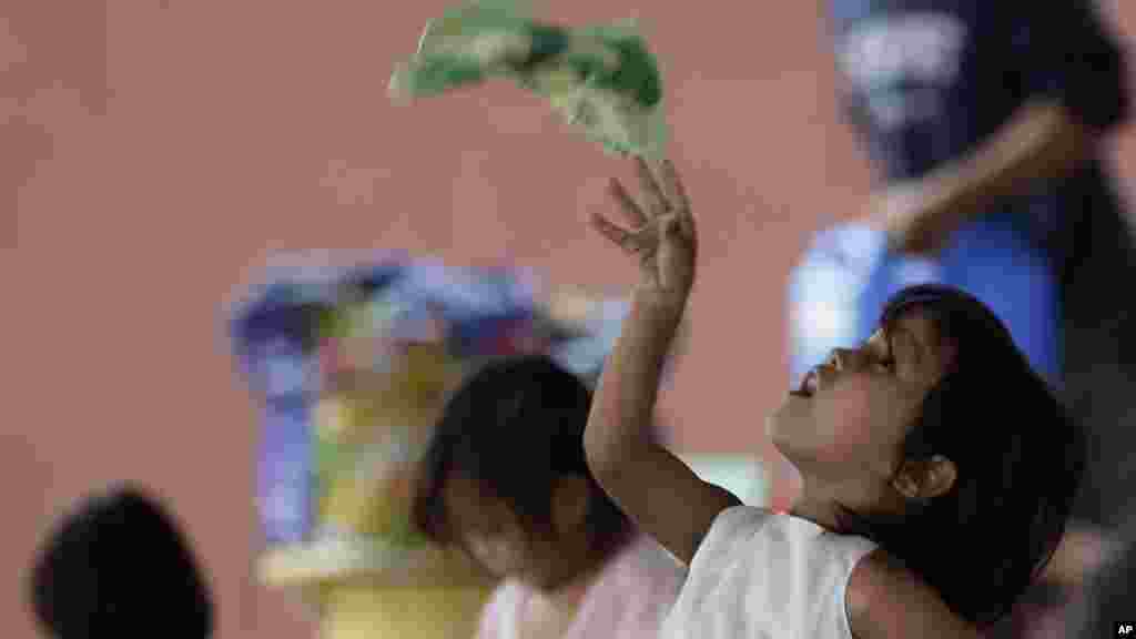 A child plays as residents are housed in an evacuation center after Friday's heavy monsoon rains spawned by Tropical Storm Fung-Wong in Marikina city, east of Manila, Philippines, Sept. 20, 2014.