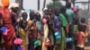 FILE - Refugees in Rwanda wait in lines for food, water, soap and other necessities that are in short supply.