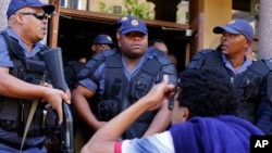 South African police disperse students after they broke a window at the University of Cape Town campus in Cape Town, South Africa, Oct. 17, 2016.