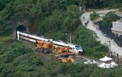 Rescue workers remove a part of the derailed train near Taroko Gorge in Hualien, Taiwan, April 3, 2021.