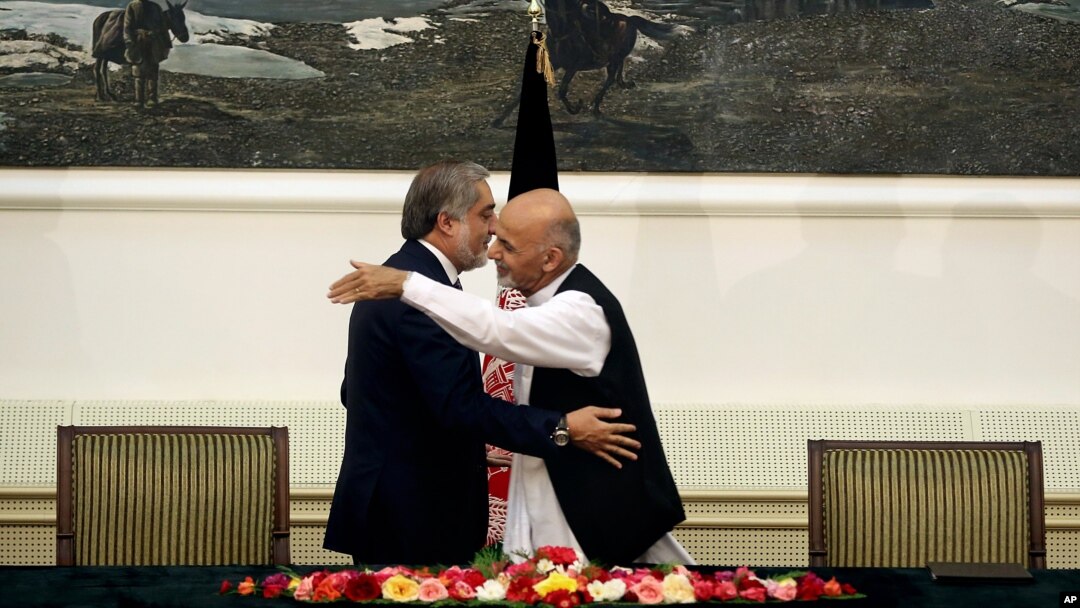 Afg'onistondagi saylovlarda qatnashgan ikki asosiy nomzod Abdulla Abdulla (chapda) va Ashraf G'ani qo'shma hukumat haqida bitim imzolagandan so'ng quchoqlashmoqda, Kobul, 21-sentabr, 2014-yil