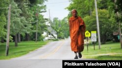 Buddhist monk Sutham Nateetong walks along the road outside Arcola, IN. June 8, 2019.