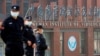 FILE - Security personnel keep watch outside the Wuhan Institute of Virology during the visit by the World Health Organization team tasked with investigating the origins of COVID-19, in Wuhan, Hubei province, China, Feb. 3, 2021.