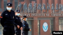 FILE - Security personnel keep watch outside the Wuhan Institute of Virology during the visit by the World Health Organization team tasked with investigating the origins of COVID-19, in Wuhan, Hubei province, China, Feb. 3, 2021.