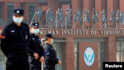 FILE - Security personnel keep watch outside the Wuhan Institute of Virology during the visit by the World Health Organization (WHO) team tasked with investigating the origins of the coronavirus disease, in Wuhan, Hubei province, China, Feb. 3, 2021.