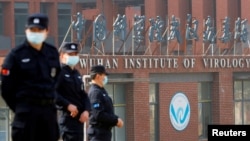 FILE - Security personnel keep watch outside the Wuhan Institute of Virology in Wuhan, Hubei province, China, Feb. 3, 2021.