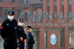 FILE - Security personnel keep watch outside the Wuhan Institute of Virology during the visit by the World Health Organization (WHO) team tasked with investigating the origins of the coronavirus disease, in Wuhan, Hubei province, China Feb. 3, 2021.