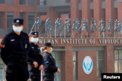 FILE - Security personnel keep watch outside the Wuhan Institute of Virology during the visit by the World Health Organization (WHO) team tasked with investigating the origins of the coronavirus disease, in Wuhan, Hubei province, China, Feb. 3, 2021.