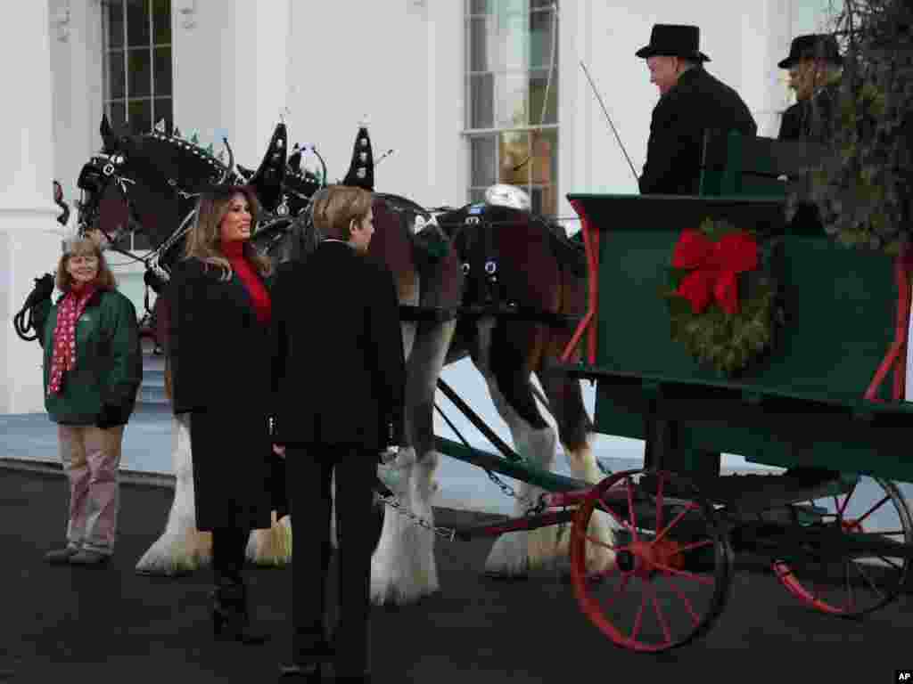 La primera dama de Estados Unidos Melania Trump, en el pórtico de la Casa Blanca saluda una carroza navideña con su hijo Barron, el 27 de noviembre de 2017.