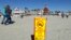 A sign warns of sewage contaminated ocean waters on a beach in front of the iconic Hotel del Coronado in Coronado, California, March 1, 2017.