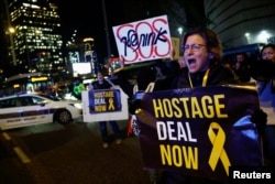 FILE - People hold banners as they take part in a protest demanding a hostage deal amid the ongoing conflict between Israel and the Palestinian Islamist group Hamas, in Tel Aviv, Israel, February 4, 2024.