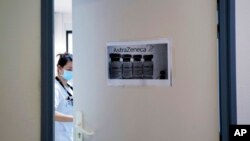 FILE - A health worker closes a door as she prepares doses of the AstraZeneca vaccine at the Edouard Herriot hospital in Lyon, central France, Feb. 6, 2021.