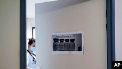 FILE - A health worker closes a door as she prepares doses of the AstraZeneca vaccine at the Edouard Herriot hospital in Lyon, central France, Feb. 6, 2021.